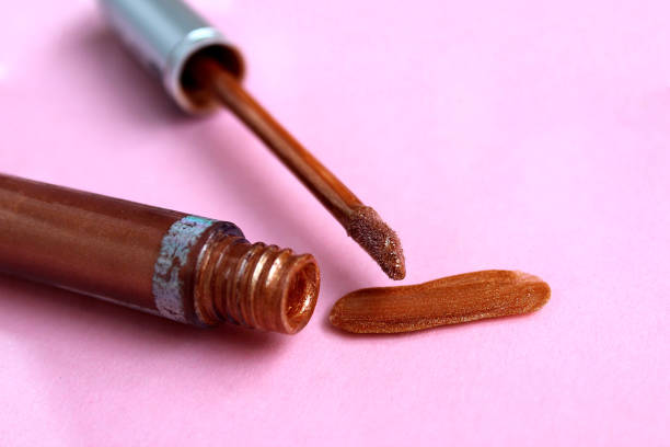 istock Brown lip gloss lies on a pink background. 1384141410