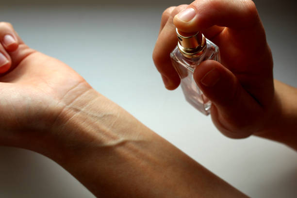 istock A woman's hand sprinkles perfume on the other hand. 1384144808