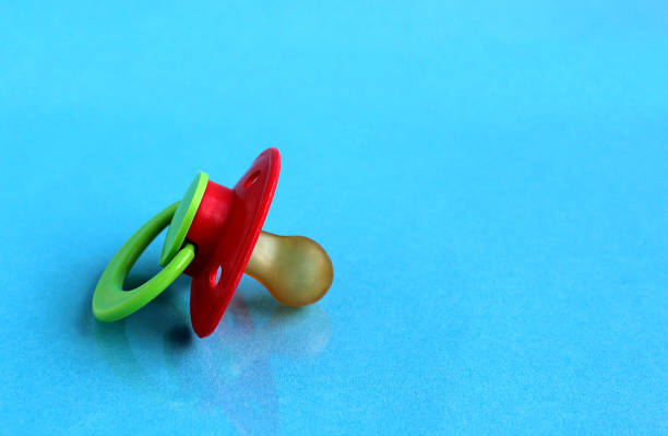 istock Baby pacifier lies on a blue background. 1384149703