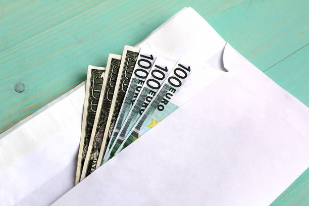 istock Dollars and euro money lie in an envelope. 1384149930