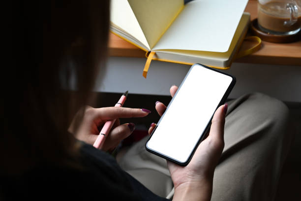 istock Young woman holding smart phone with white blank display for graphic display montage. 1384153510