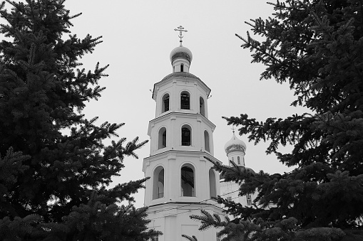 Black and white photo. Bell tower church tower with a cross.