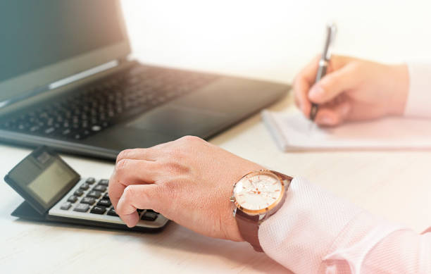 istock man's hands with calculator, notepad and laptop on the table 1384158159
