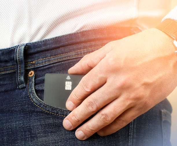 credit card in jeans pocket and man's hand