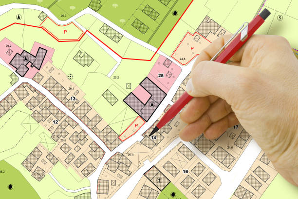 istock Engineer drawing over an imaginary General Urban Plan of territory with buildings, roads and land parcel - note: the map is totally invented and does not represent any real place 1384158192