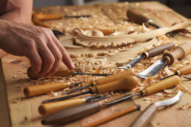 Man working with woodcarving instruments Woodworker's workbench. Closeup man's hand. A man working with woodcarving instruments. carpenter carpentry craftsperson carving stock pictures, royalty-free photos & images