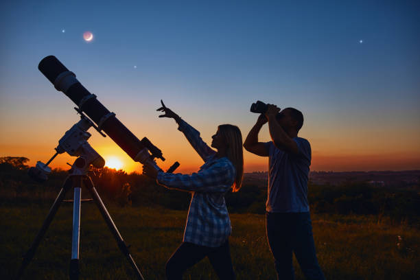 istock Couple stargazing together with a astronomical telescope. 1384162812