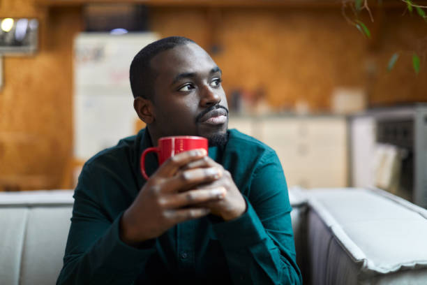 istock A young man is sitting at home drinking coffee. 1384176330