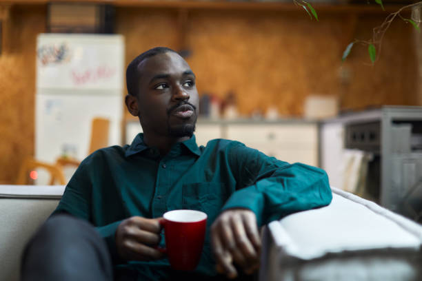 istock A young man is sitting at home drinking coffee. 1384176345