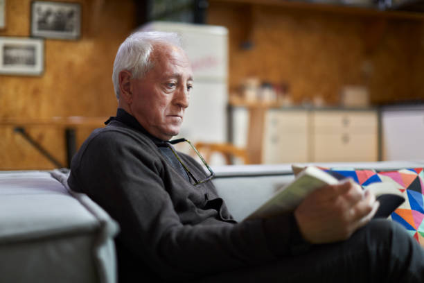 istock A retired man is reading a book at home. 1384176491