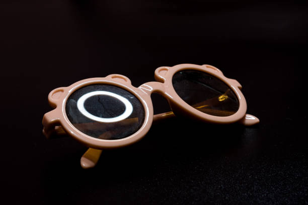 istock pink children's glasses on a black background 1384199950