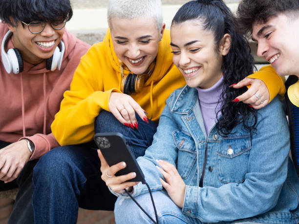 istock Group of young students looking at smart phone smiling. social media, having fun 1384203664