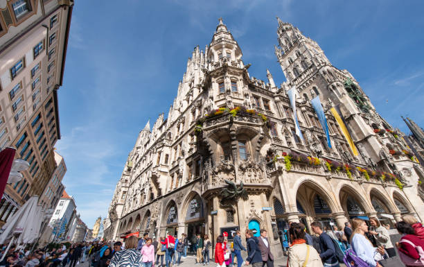Munich, Germany - September 20, 2020: Very busy Marienplatz, in the city center of Munich with many shops. Historical city hall with the world famous carillon clock tower in middle.