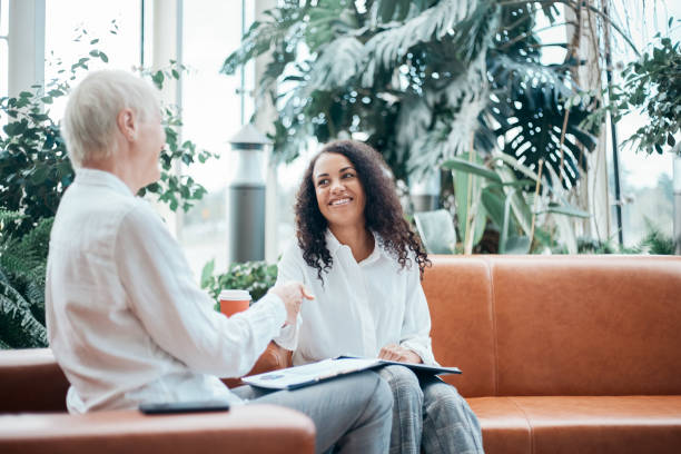 financial consultant greeting the client with a handshake - interview meeting business women imagens e fotografias de stock