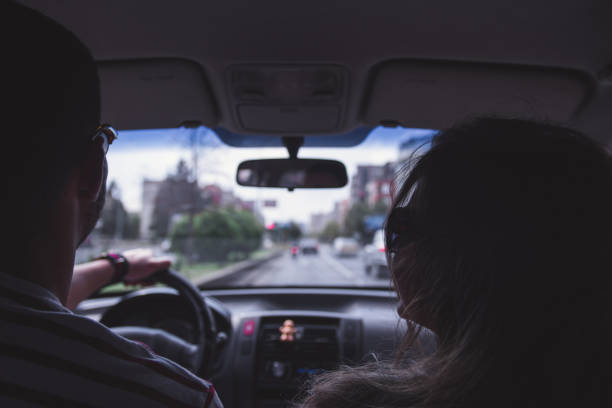 Couple is stopped by the police. The man is giving the policeman his drivers license.