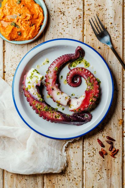 octopus with garlic and parsley, and romesco sauce stock photo