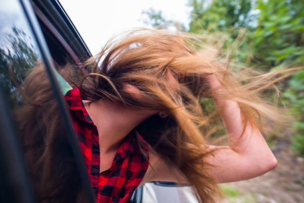 istock Woman with head up having fun on a windy day car drive 1384207952