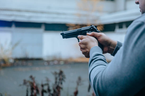 istock Policeman aiming a gun on the street 1384208038