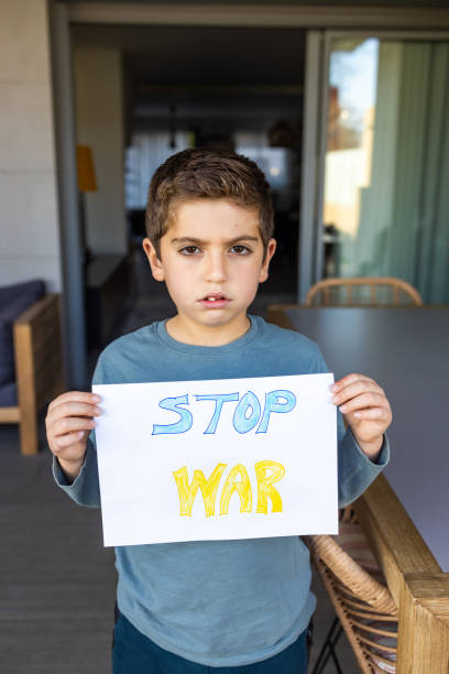 istock Young Boy Holding Stop War Sign 1384208566