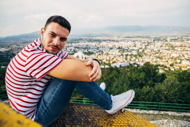 istock Cheerful man sitting on a metal construction 1384213502