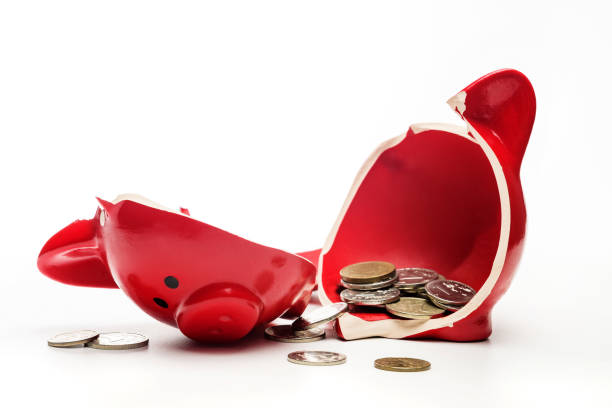 istock broken piggy bank with coins isolated on white background. 1384217403