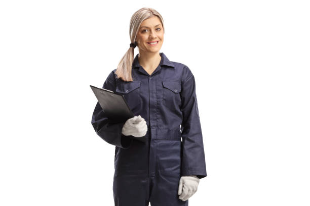 istock Young female worker in an overall uniform standing with a clipboard 1384217726