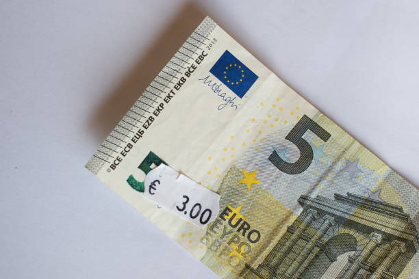 Inflation in Europe, hyper inflation, devaluation concept. Five euro banknote with three euro price tag. Selective focus on label. devaluation stock pictures, royalty-free photos & images