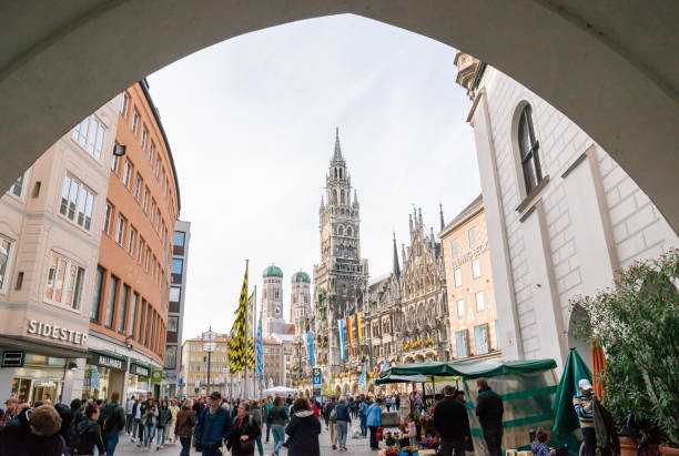 Munich, Germany - September 20, 2020: Very busy Marienplatz, in the city center of Munich with many shops. Historical city hall with the world famous carillon clock tower in middle.