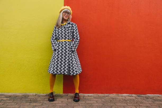 istock Mature woman standing against a colourful background 1384221556
