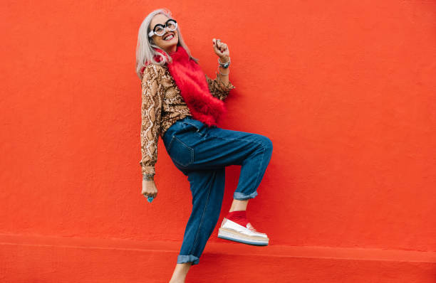 istock Active senior woman dancing against a red background 1384222109