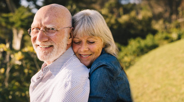 istock Happy mature couple embracing each other in a park 1384223152