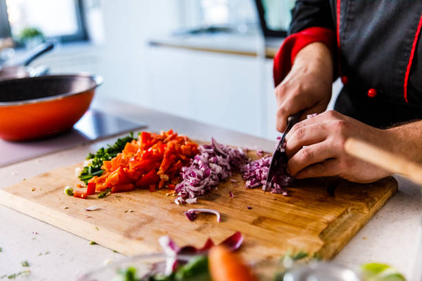 istock Midsection of professional chef dicing up a red onion 1384224298