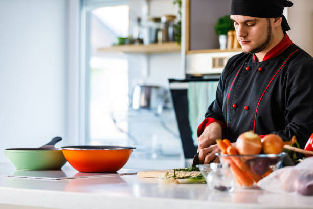 istock Professional chef chopping up dill and other herbs with a kitchen knife 1384224307