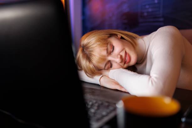 istock Woman sleeping at her desk while working overtime 1384224468