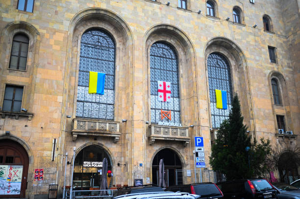 TBILISI, GEORGIA - MARCH 11, 2021. Ukrainian and Georgian flags are waving hang on houses, buildings, shop windows, apartment balcony in support of Ukraine. stock photo
