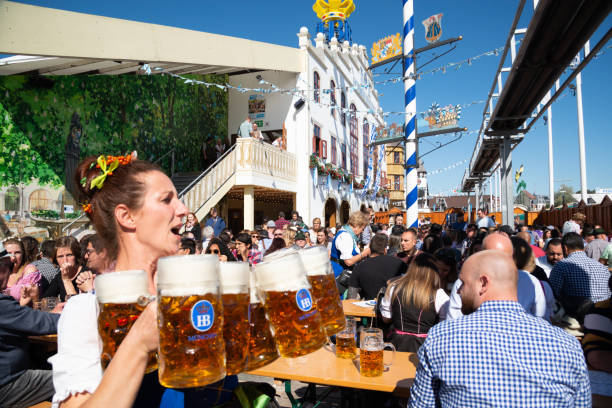 waitress carrying beer glasses at the oktoberfest in munich, germany - oktoberfest imagens e fotografias de stock