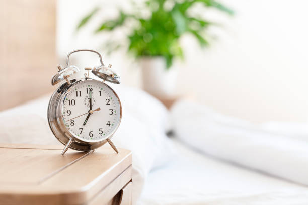 hora do despertador da manhã acordar no fundo da mesa de cabeceira - manhã - fotografias e filmes do acervo