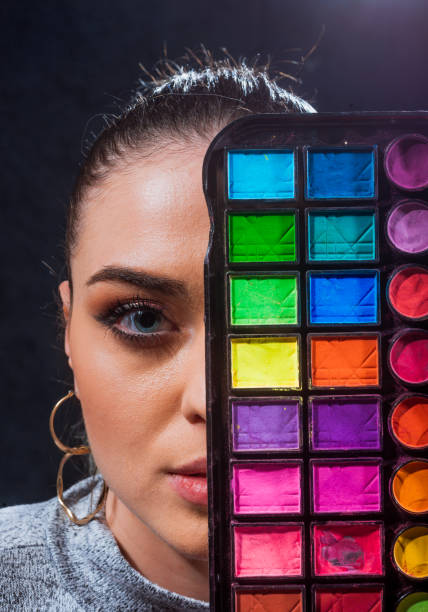Close up shot of a beautiful makeup artist posing with her makeup palette