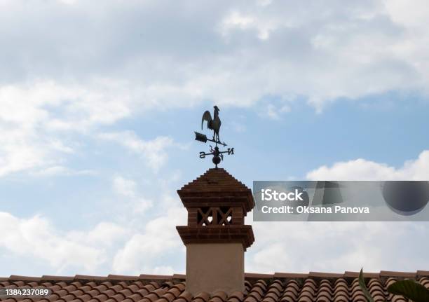 Weather Vane In The Form Of A Rooster On The Roof Stock Photo - Download Image Now - Rooster, Wind, Navigational Compass