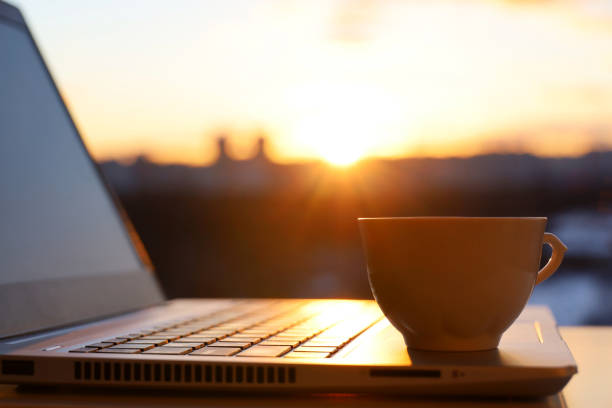 istock Coffee cup on laptop against the window with sunshine 1384241643
