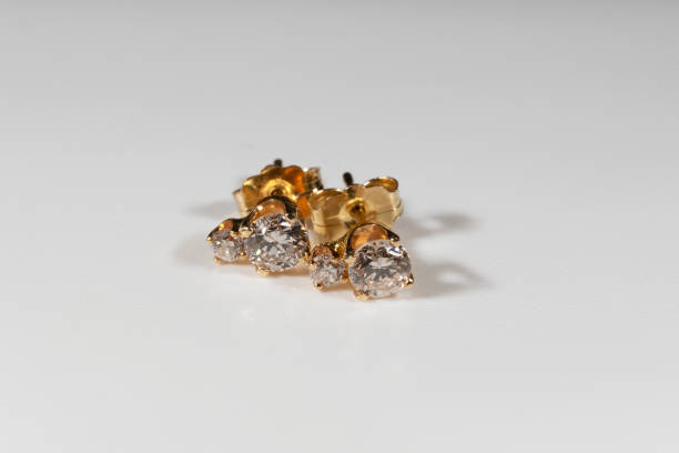 istock Yellow gold earrings with natural round diamonds on a white background 1384246227