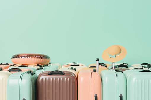 many suitcases stacked with summer travel accessories