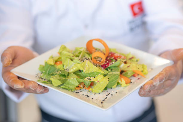istock a hand holding a plate of salad 1384247773