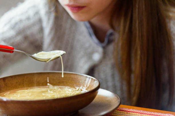 Chicken noodle soup in a white bowl isolated on a white background.