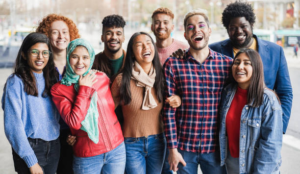 giovani persone diverse che si divertono all'aperto ridendo insieme - concetto di diversità - focus principale sul volto dell'uomo gay - multi ethnic group foto e immagini stock