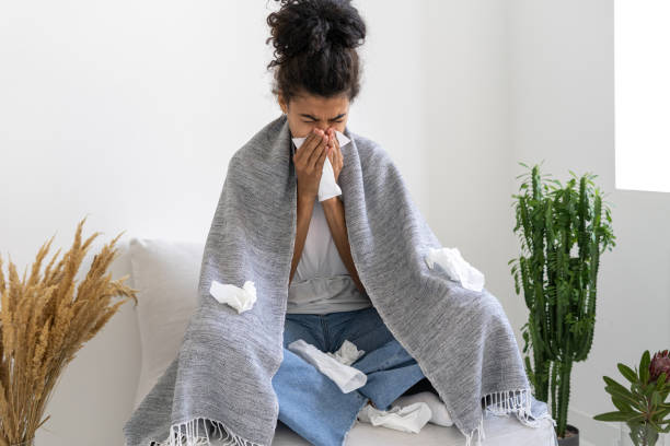 istock Tired afro american lady sneezing in handkerchief 1384248809