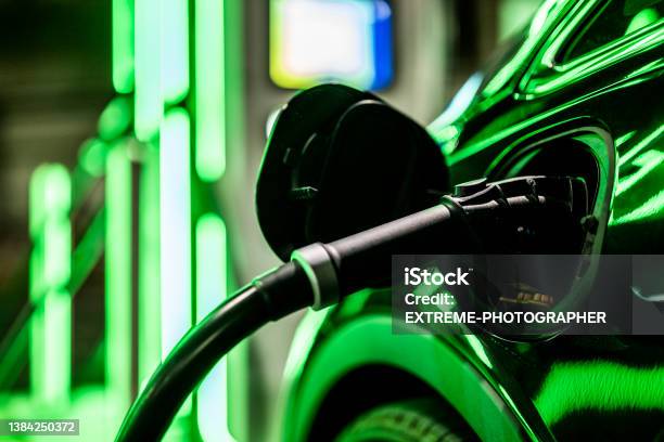 Electric Car Charger And Green Reflection From The Light Stock Photo - Download Image Now