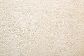 Beige new fluffy home carpet background. Closeup. Empty place for text. Top down view.