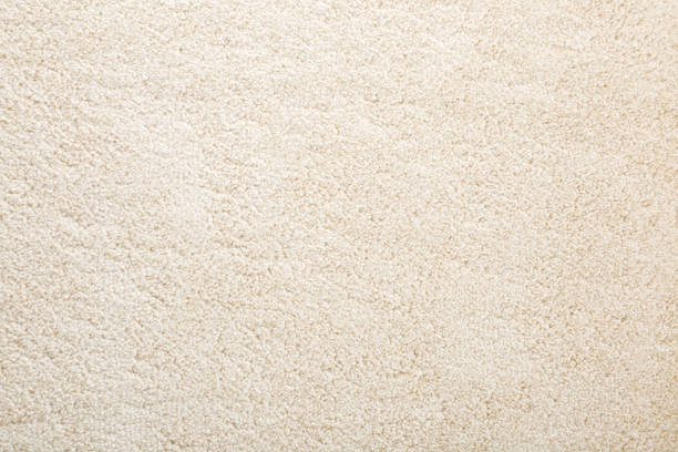 Beige new fluffy home carpet background. Closeup. Empty place for text. Top down view. stock photo