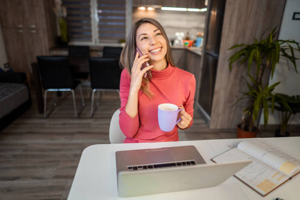 istock Lovely brunette taking a break from work and talking on a phone 1384251763
